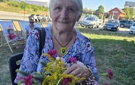 osoba trzymająca kwiaty