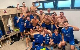 osoby w pomieszczeniu cieszace się z sukcesu piłkarskiego