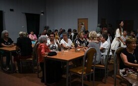 grupa os&oacute;b siedzących na sali