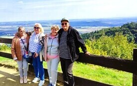 osoby opierające się o płot a za nimi g&oacute;rskie widoki