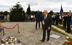 osoba składająca znicz pod pomnikiem