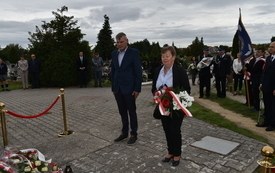 osoby składające kwiaty pod pomnikiem