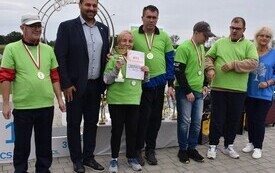 osoby w zielonych koszulkach z dyplomem