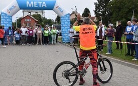 osoby na starcie z kijkami i pan na rowerze