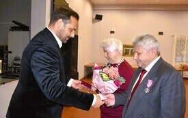 osoba wręczajaca książeczkę
