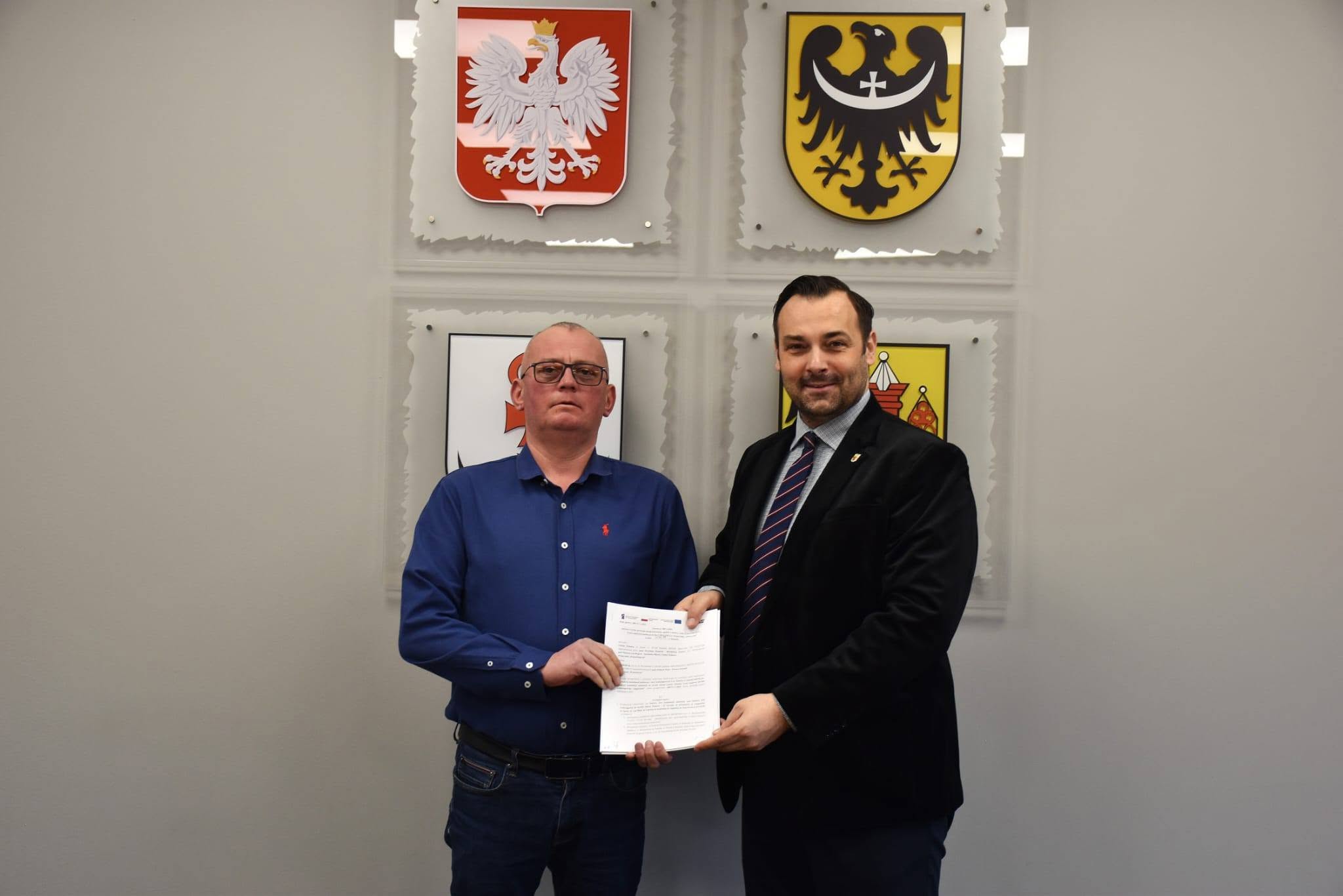 dw&oacute;ch pan&oacute;w stojących i&nbsp;trzymających w&nbsp;rękach dokument