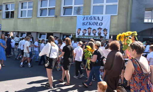 Dzieci przed budynkiem szkoły